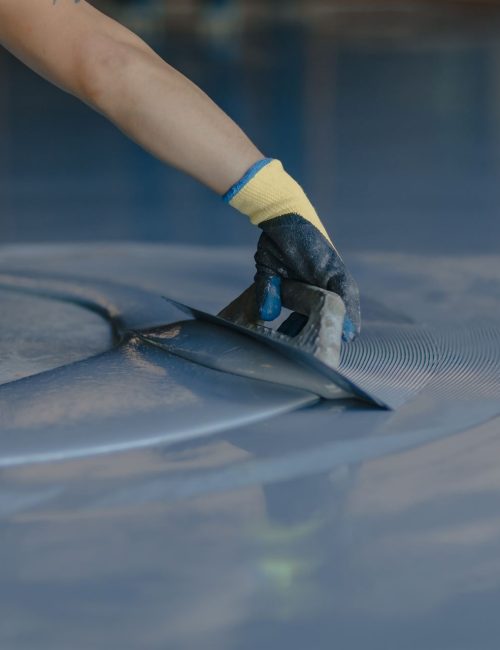 The worker applies gray epoxy resin to the new floor